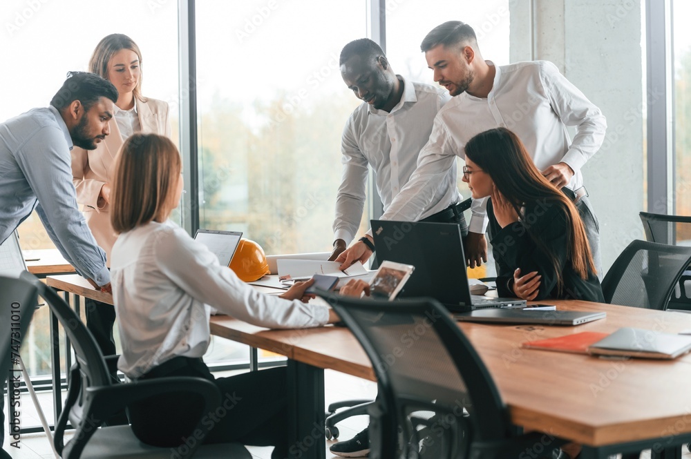 Team are busy and bringing the ideas for project. Group of office workers are together indoors Team are busy and bringing the ideas for project. Group of office workers are together indoors