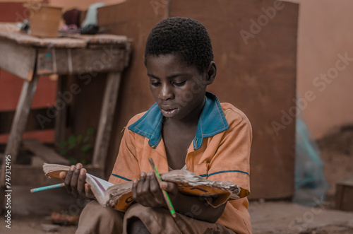 Canvastavla A young boy reading a text book.