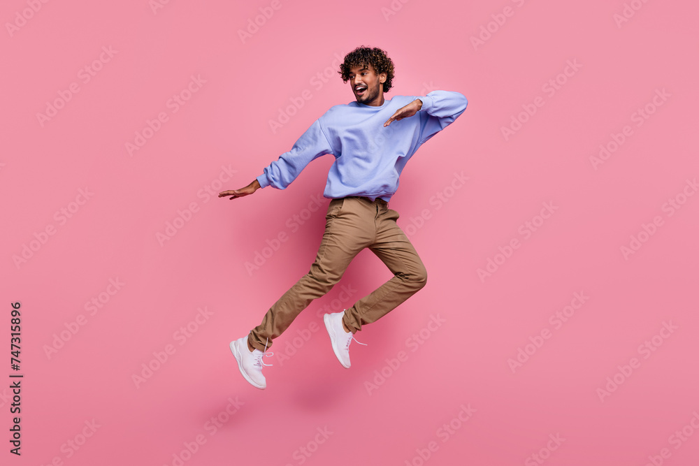 Photo of crazy positive optimistic man wear stylish clothes jump up dance celebrate party empty space isolated on pink color background