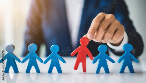 businessperson selects red human figures among blue ones, symbolizing choice and leadership in diversity
