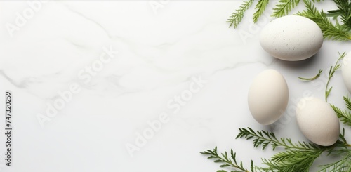 Minimalistic Easter layout. White Eggs and Greenery on Marble Surface. Spring Easter Theme. Minimal flat lay concept.