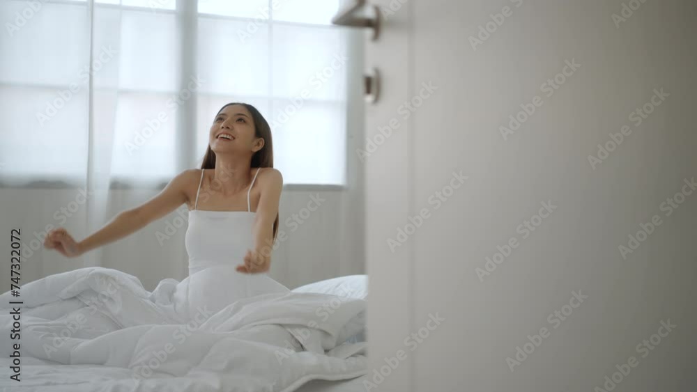 Refreshing moment of asian woman wake up and stretching in bed at sunrise. Happy female waking up and ready to start new day in the morning. Have a good day. Refreshing moment of asian woman wake up and stretching in bed at sunrise. Happy female waking up and ready to start new day in the morning. Have a good day.