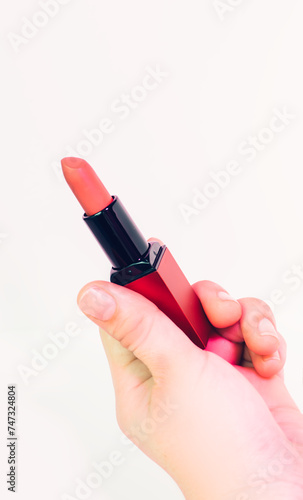 Holding the lipstick. It can used on poster  banner and social media postings.