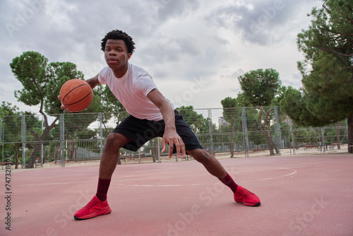 Basketball player training on a court in the city © Oscar