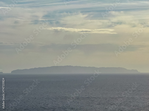 Panoramic view of remote island Desert Grande seen from Cristo Rei in Garajau, Madeira island, Portugal, Europe. Looking at horizon of majestic Atlantic Ocean. Tranquil serene atmosphere