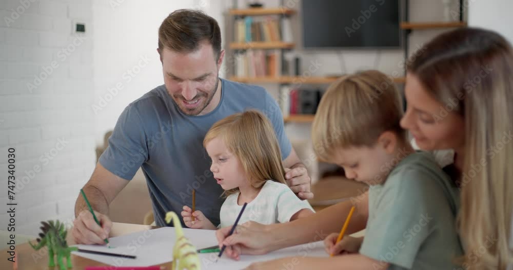 Happy family with two children drawing together at home Happy family with two children drawing together at home