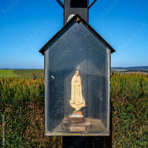 Figurine of the Virgin in a cabinet beside the road
