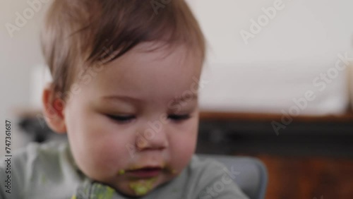 Smiling baby boy covered in avocado