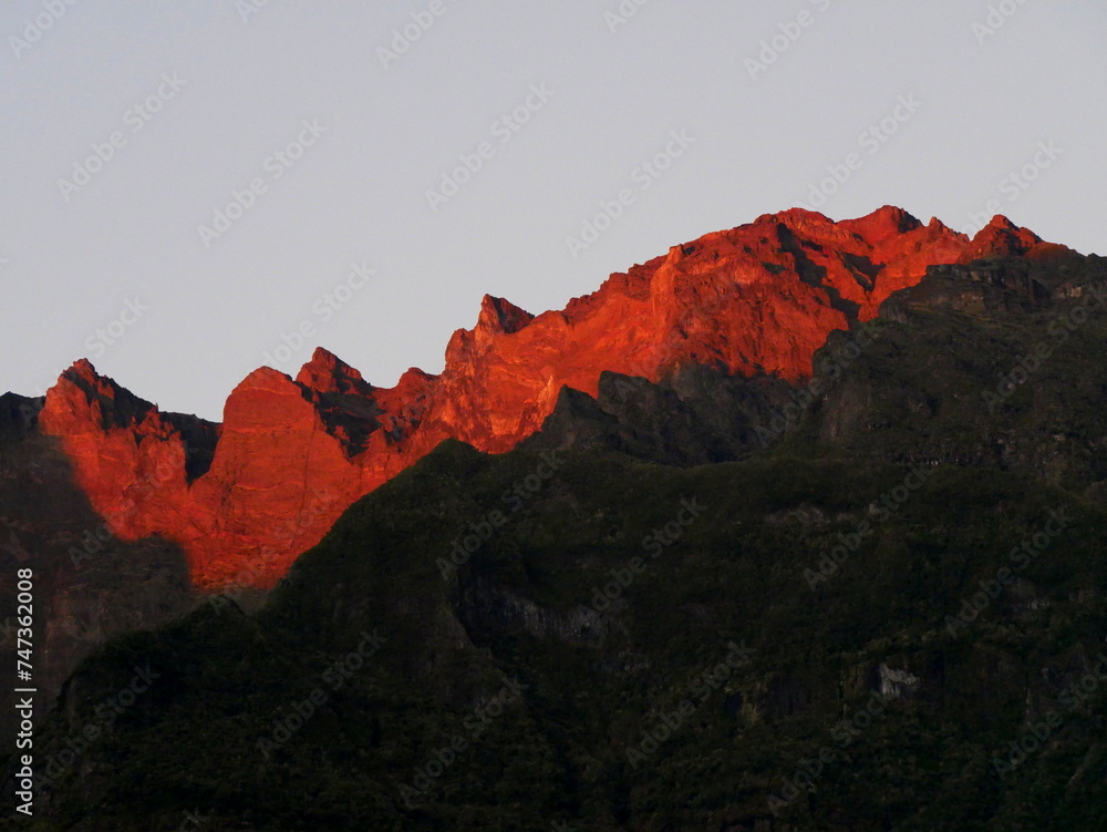 Red light of sunset over the Piton des neiges mountain summit from Cilaos, Reunion