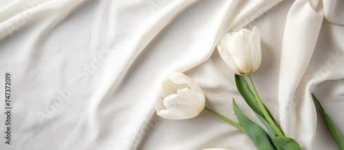 A cluster of white flowers lying on a white linen sheet  creating a simple and elegant composition. The delicate blooms contrast beautifully with the natural fabric backdrop.