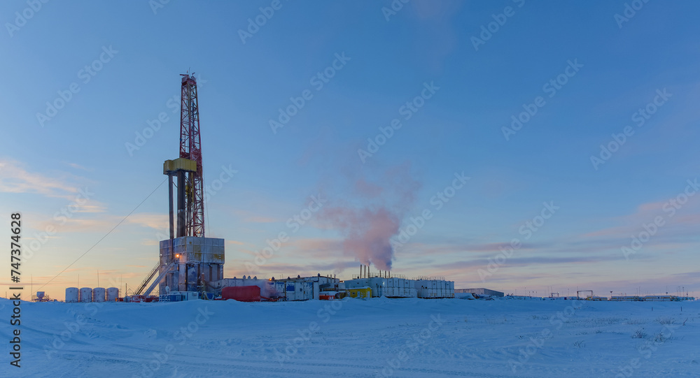 Drilling rig and equipment for drilling oil and gas wells in the Arctic. Madachag oil and gas field in the Barents Sea. Winter polar day. Blue sky, snowy and frosty weather Drilling rig and equipment for drilling oil and gas wells in the Arctic. Madachag oil and gas field in the Barents Sea. Winter polar day. Blue sky, snowy and frosty weather