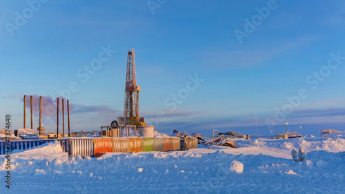 Drilling rig and equipment for drilling oil and gas wells in the Arctic. Madachag oil and gas field in the Barents Sea. Winter polar day. Blue sky, snowy and frosty weather photo
