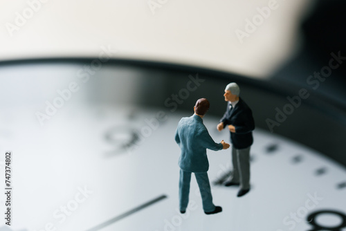 時計の上で交渉するビジネスマンの人形 © taa22