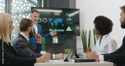 Expert business man using interactive whiteboard to show his multiethnic attentive listeners problematic ecological zones on our earth