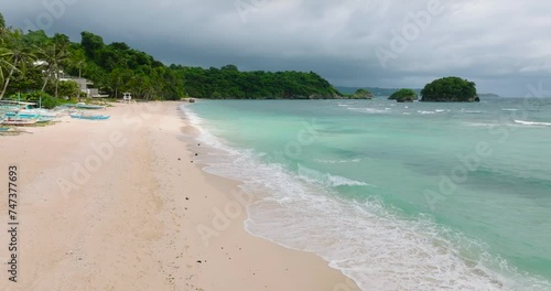 Inshore ocean waves crashing on white sand in Ilig Iligan Beach. Boracay, Philippines. photo