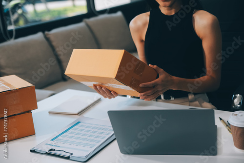 businesswoman start small business and successful SME entrepreneurs asian woman hoding boxs works from home delivering parcels online. SME delivery concept and packaging