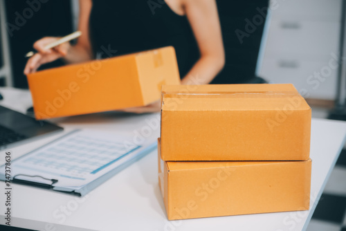 businesswoman start small business and successful SME entrepreneurs asian woman hoding boxs works from home delivering parcels online. SME delivery concept and packaging © ARMMY PICCA