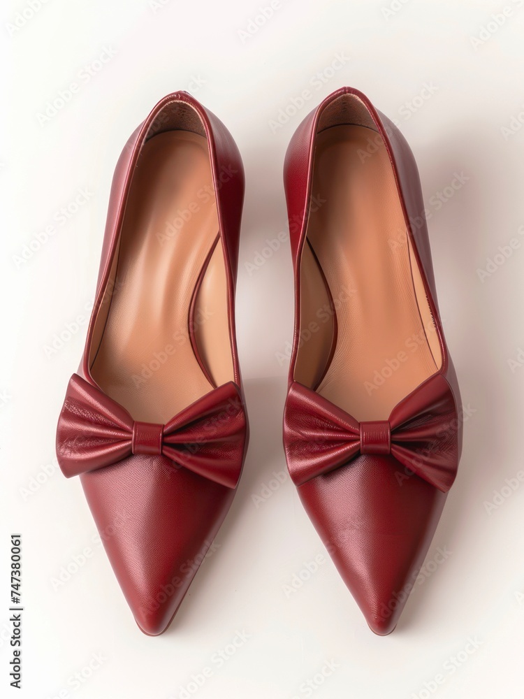 Pair of dark red shoes decorated with bows on white background. Pair of dark red shoes decorated with bows on white background.