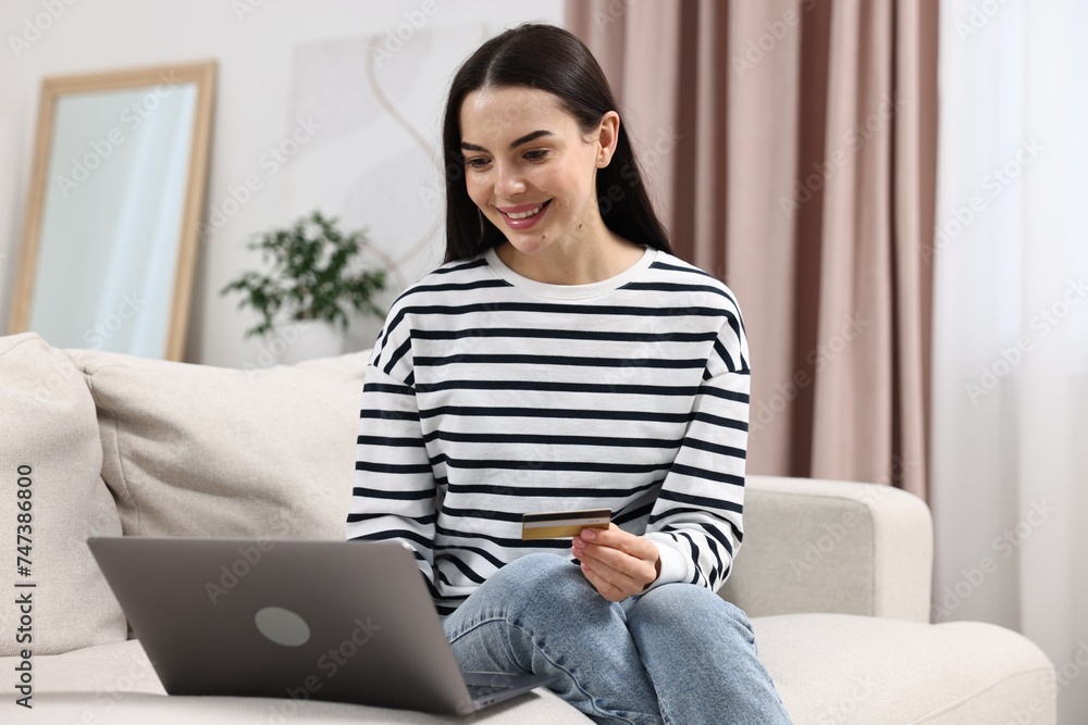 Happy young woman with credit card and laptop shopping online at home Happy young woman with credit card and laptop shopping online at home