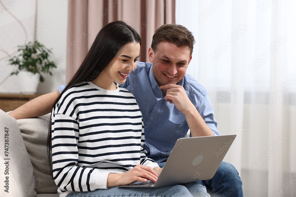 Happy couple using laptop together at home Happy couple using laptop together at home