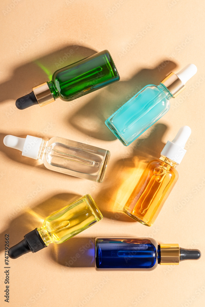 glass dropper bottles with beauty oils or serum on beige background. Skincare products with beautiful daylight. Trending concept natural cosmetic with plant shadow .Beauty concept glass dropper bottles with beauty oils or serum on beige background. Skincare products with beautiful daylight. Trending concept natural cosmetic with plant shadow .Beauty concept