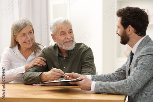 Notary consulting senior couple about Last Will and Testament in office