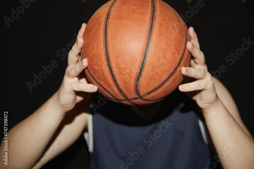 The hands of a basketball player hold the ball in front of them instead of the head on a black background, sports thinking, individual technique in basketball, basketball training © Александр Ланевский