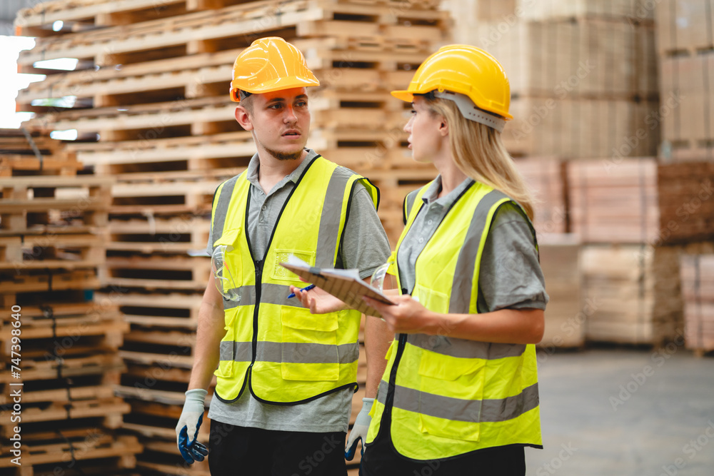 Man and woman workers with clipboard discussing working and checking stock inventory wood plank material for making wooden pallet products at warehouse industrial factory, woodwork production Man and woman workers with clipboard discussing working and checking stock inventory wood plank material for making wooden pallet products at warehouse industrial factory, woodwork production