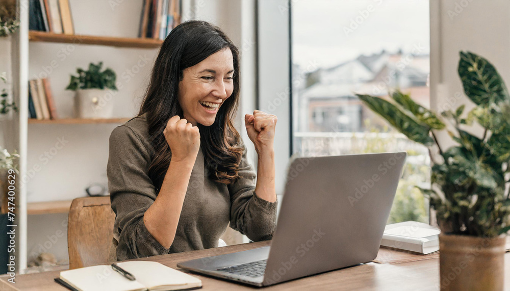 woman working on laptop and celebrating her success; happy businesswoman working from home woman working on laptop and celebrating her success; happy businesswoman working from home
