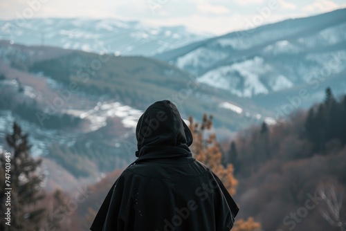 russian orthodox monk standing in mountains from his back in mountains