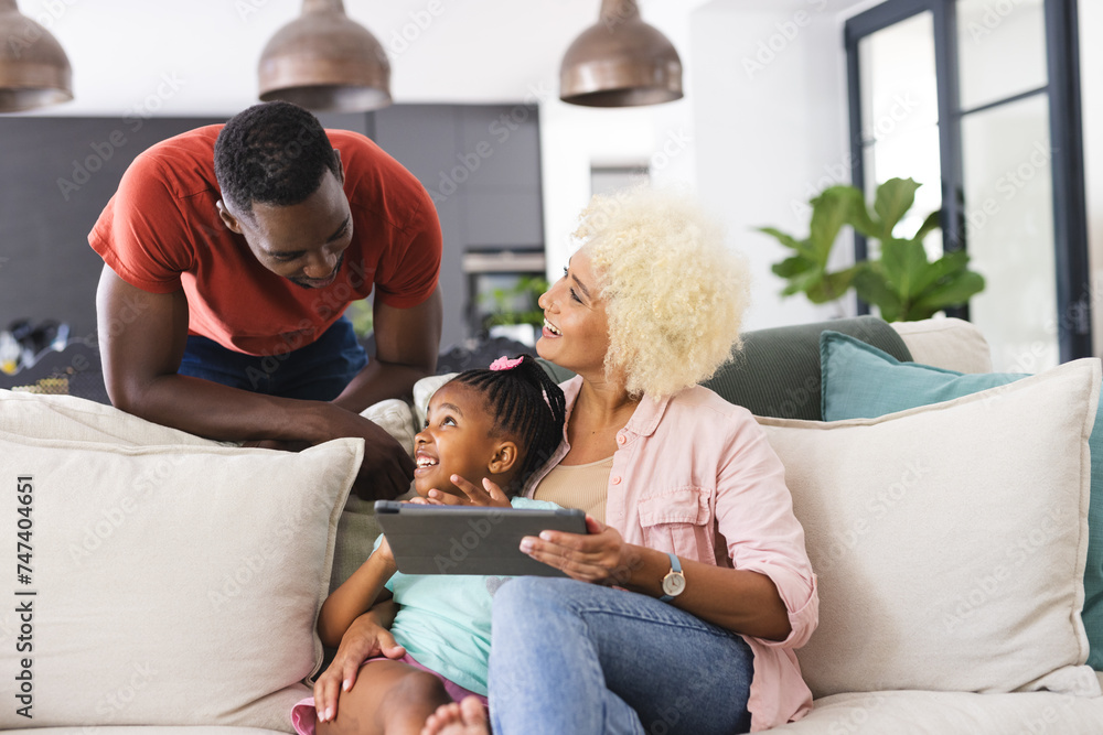 African American father and mother enjoy time with their daughter, using a tablet African American father and mother enjoy time with their daughter, using a tablet