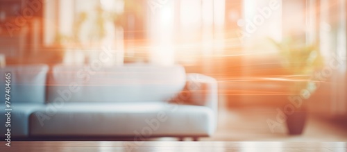 A blur effect is applied to a living room showcasing a couch as the main focal point. The room appears slightly vintage with soft lighting.