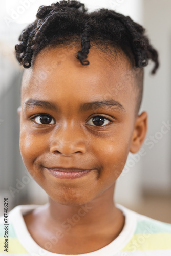 African American boy with a cheerful smile, wearing braids photo