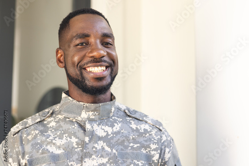 African American soldier in military uniform smiles warmly with copy space photo