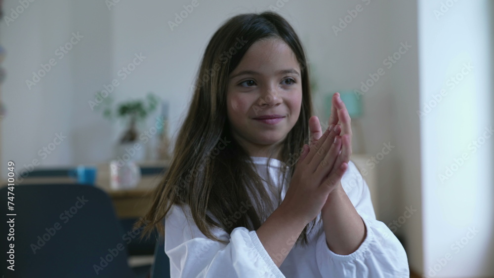 Child clapping hands, one small girl showing congratulations