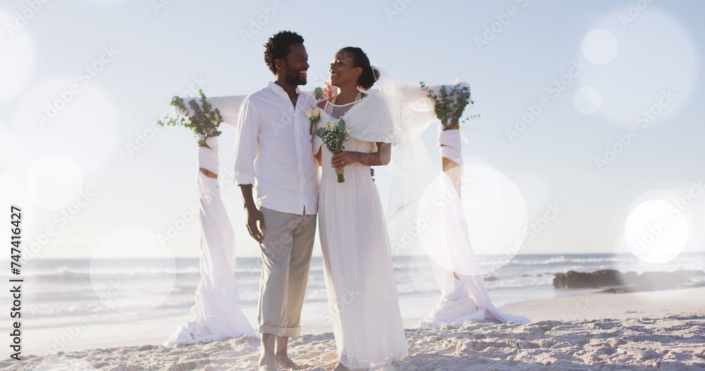 Naklejka premium Image of dots over happy african american newly married couple on beach