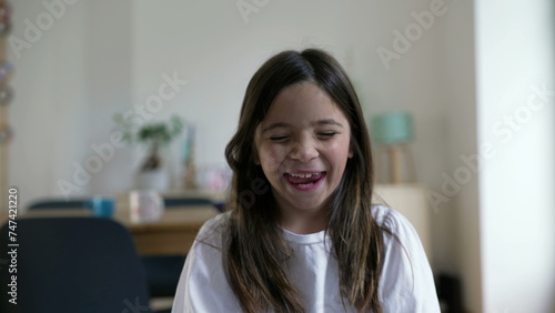 Free Download One happy little girl bursts laughing out loud. Close-up child face feeling joy in carefree moment, authentic real life laugh and smile - GFXLoad