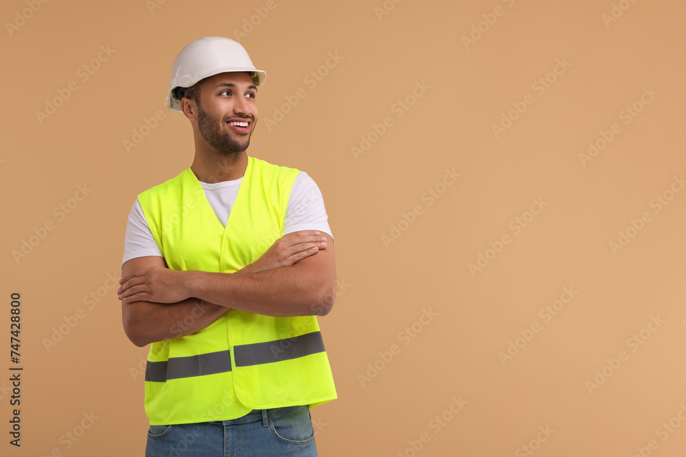 Engineer in hard hat on beige background, space for text