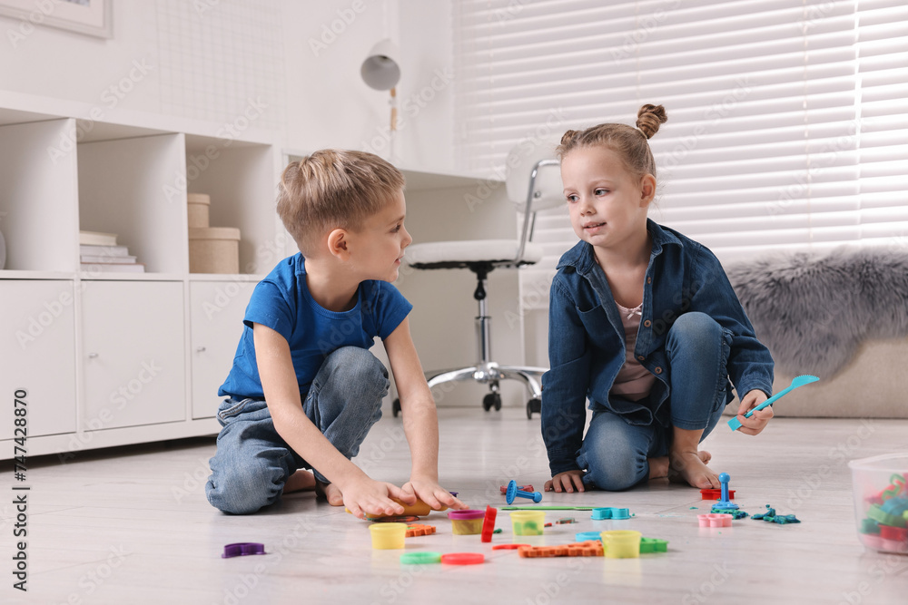 Obraz premium Cute little children playing on warm floor at home. Heating system