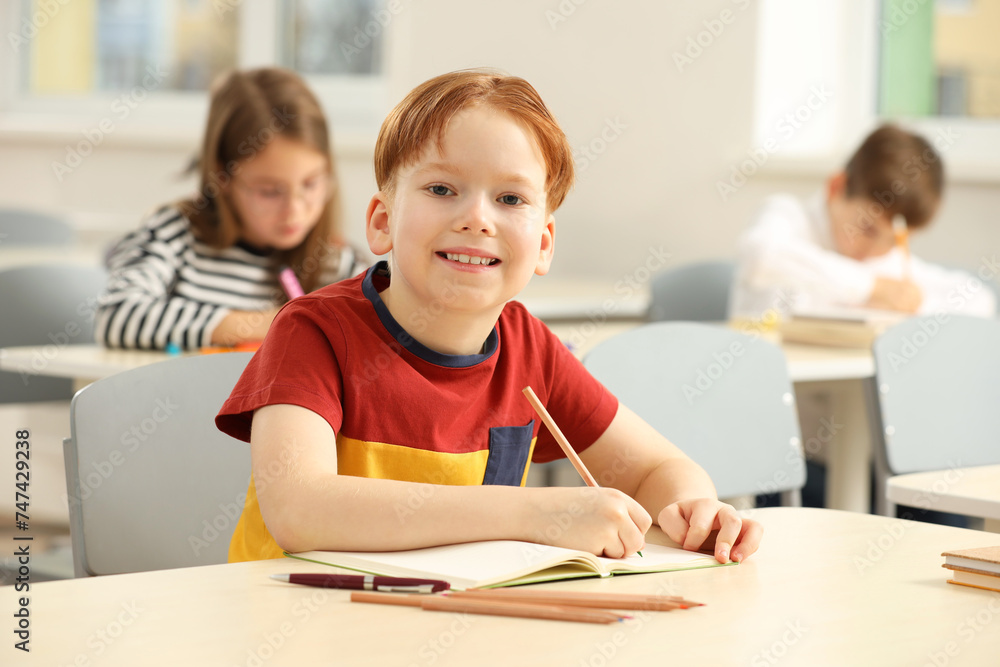 Portrait of smiling little boy studying in classroom at school Portrait of smiling little boy studying in classroom at school
