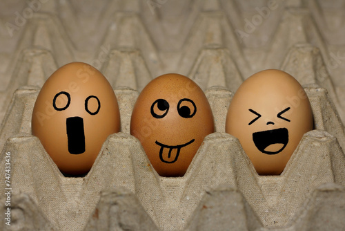 Photography three eggs drawn with character faces on an egg carpet with a black background l