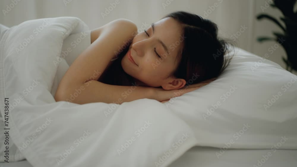 Relaxing moment of Beautiful asian woman have sweet dreams and deep sleep in bed comfortably with pillows. She sleeping on white bedding in light bedroom in morning. Have a good day. Relaxing moment of Beautiful asian woman have sweet dreams and deep sleep in bed comfortably with pillows. She sleeping on white bedding in light bedroom in morning. Have a good day.