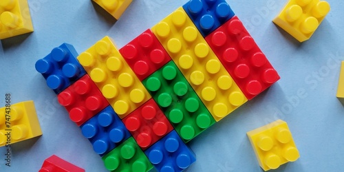 Colorful plastic building blocks on blue background with copy space for education and creativity concept