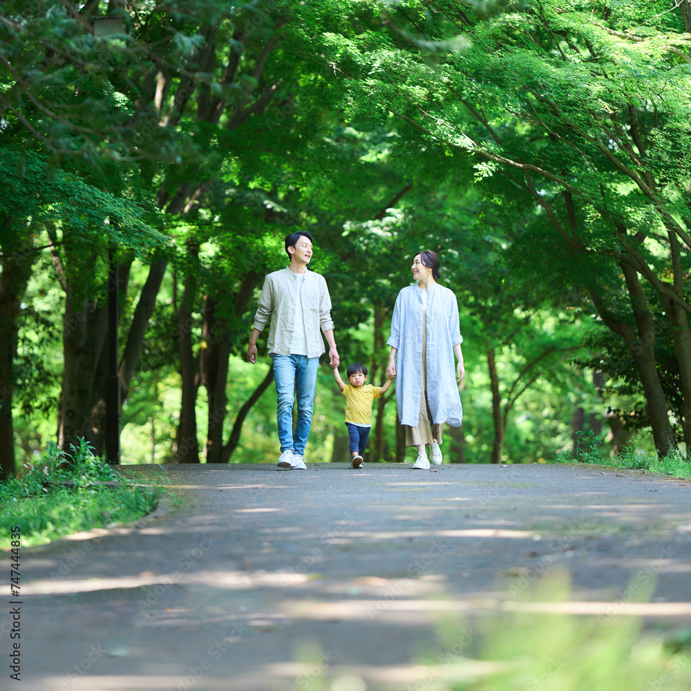 手を繋いで公園を歩く家族