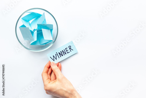 Lottery winner ticket near glass bowl full of paper sheets. Winner concept