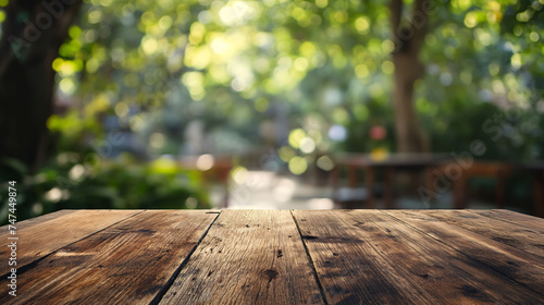 Wooden table top with blurred bokeh light background in a vintage street cafe setting.