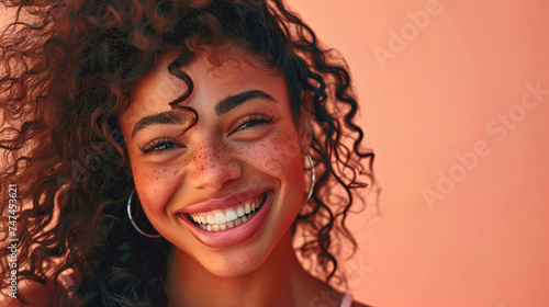 Beautiful young happy African woman against peach fuzz colored background