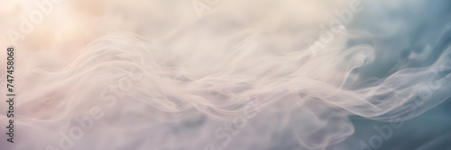 Close-up photograph of delicate wisps of smoke gently unfurling against a background of soft, pastel hues. © Hans