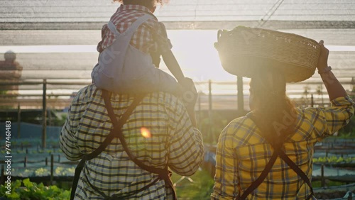 Young african american family spending time together at the farm,with their little daughter in the field or glasshouse.business owner farmer family,sustainability,sustainable and agriculture concept photo