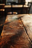 Close up of a wooden table with chairs in the background. Ideal for interior design concepts